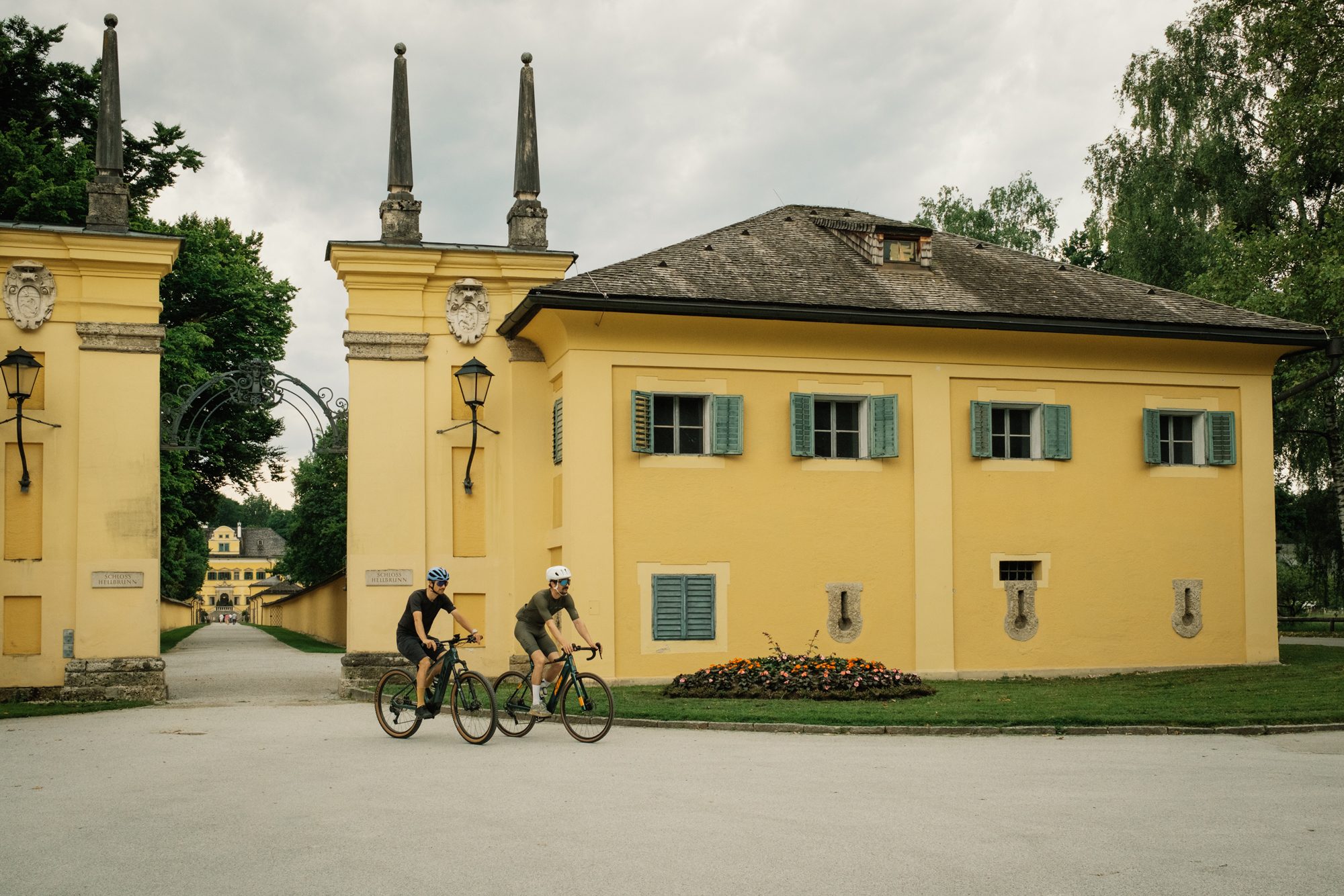 Zwei Fahrradfahrer vor den Toren des Schloss Hellbrunns in Salzburg